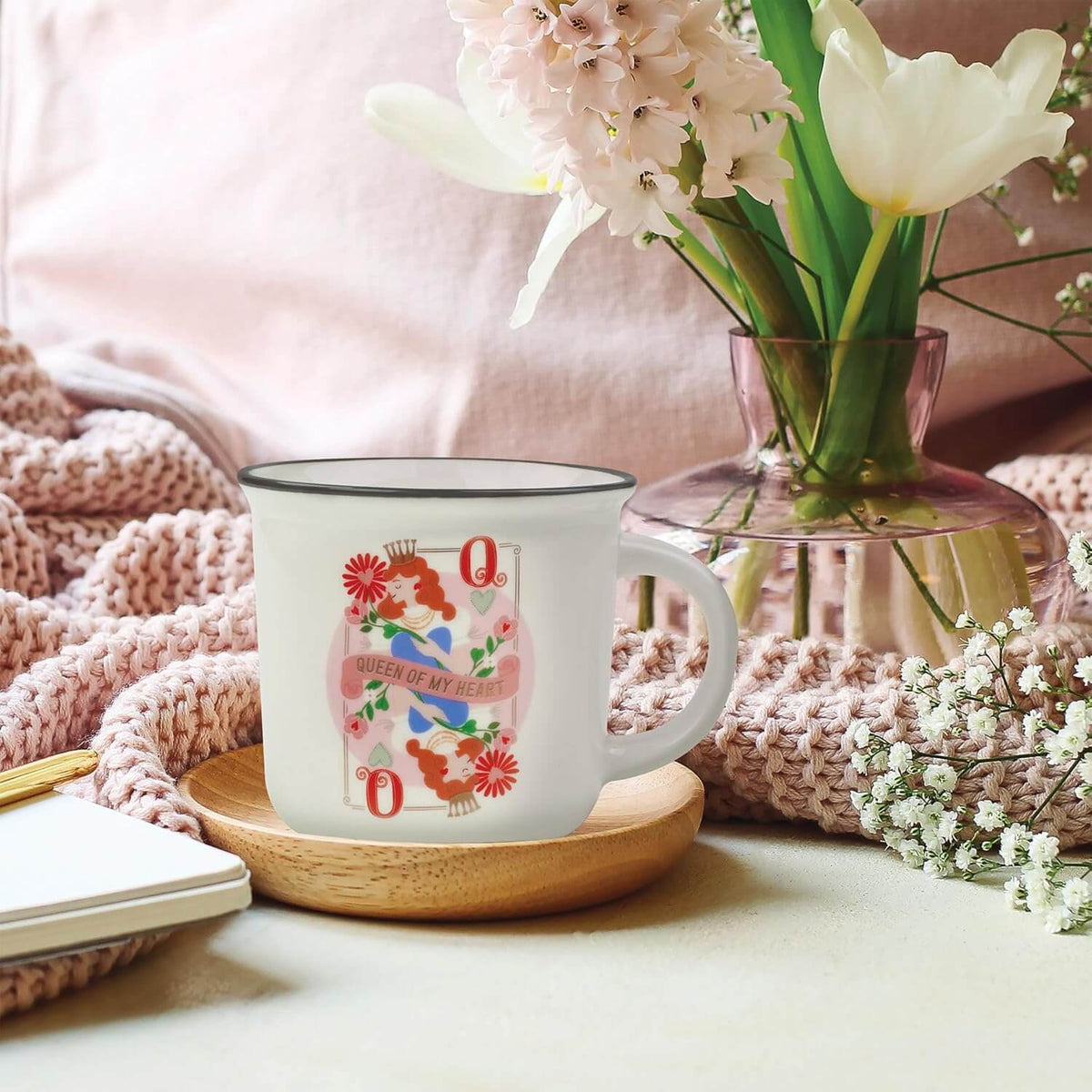Tazza da colazione Legami riposta su piattino in legno in un contesto casalingo con fiori e coperta